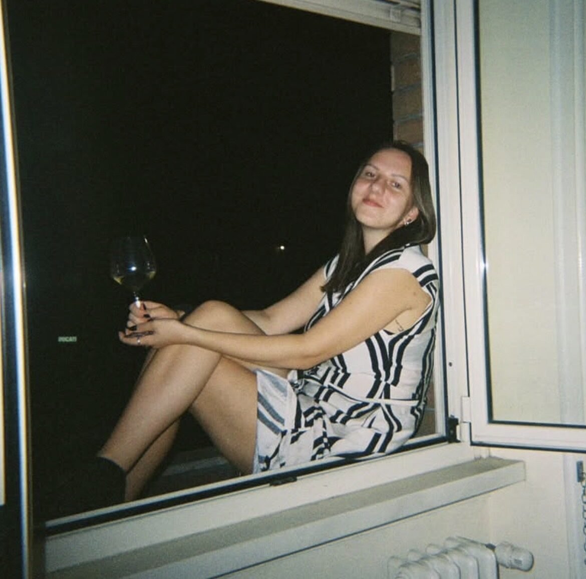 Urtė smiling outdoors in a patterned cardigan